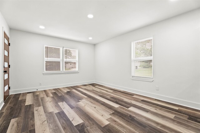 spare room with baseboards, recessed lighting, and dark wood-type flooring