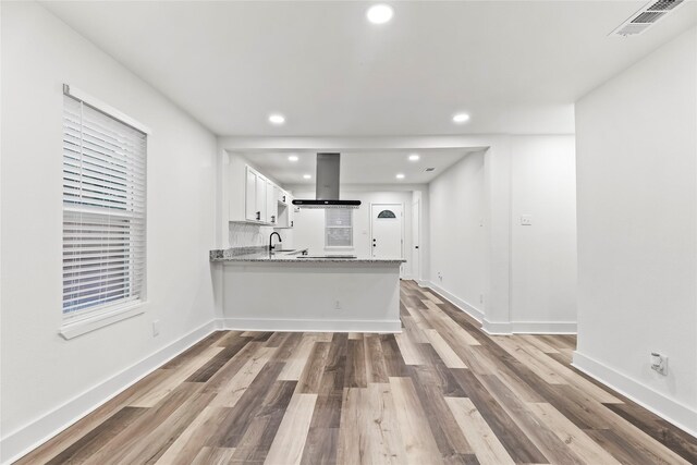 kitchen with white cabinetry, recessed lighting, island exhaust hood, wood finished floors, and visible vents