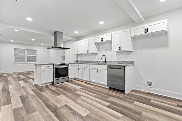 kitchen with a peninsula, appliances with stainless steel finishes, white cabinetry, and island exhaust hood