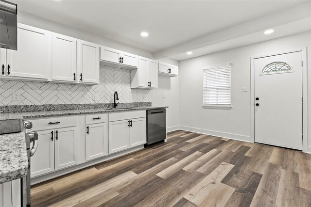 kitchen with appliances with stainless steel finishes, tasteful backsplash, a sink, recessed lighting, and white cabinetry