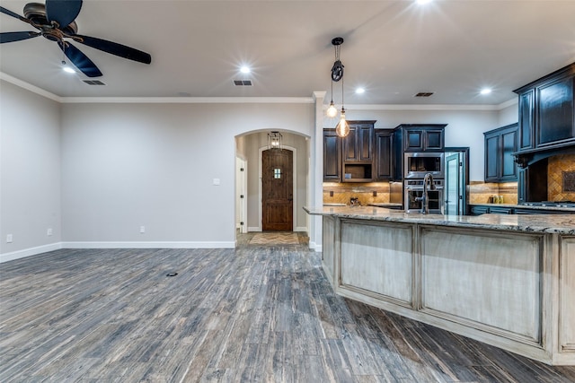 580 Leatherwood Ln, Poolville, TX 76487 - kitchen featuring baseboards, arched walkways, tasteful backsplash, a ceiling fan, and appliances with stainless steel finishes