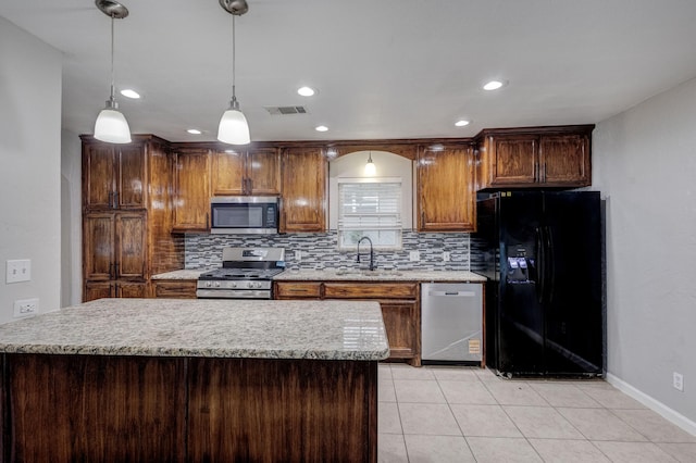 kitchen featuring appliances with stainless steel finishes, a sink, baseboards, light tile patterned floors, and tasteful backsplash