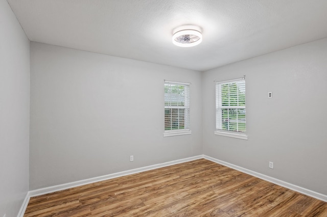 unfurnished room with baseboards and wood finished floors