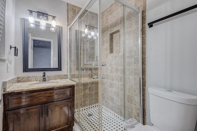 bathroom featuring vanity, toilet, and a shower stall