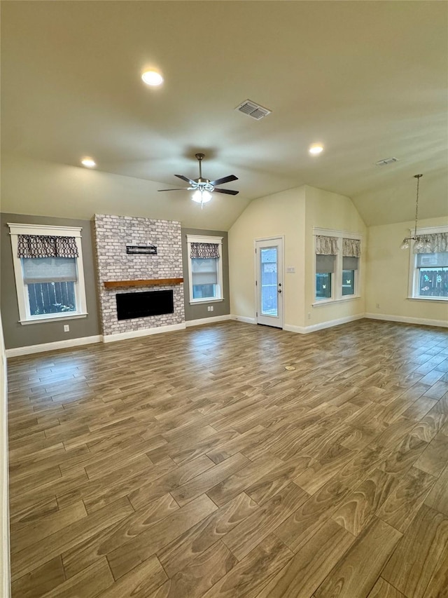 unfurnished living room with baseboards, ceiling fan, vaulted ceiling, and wood finished floors