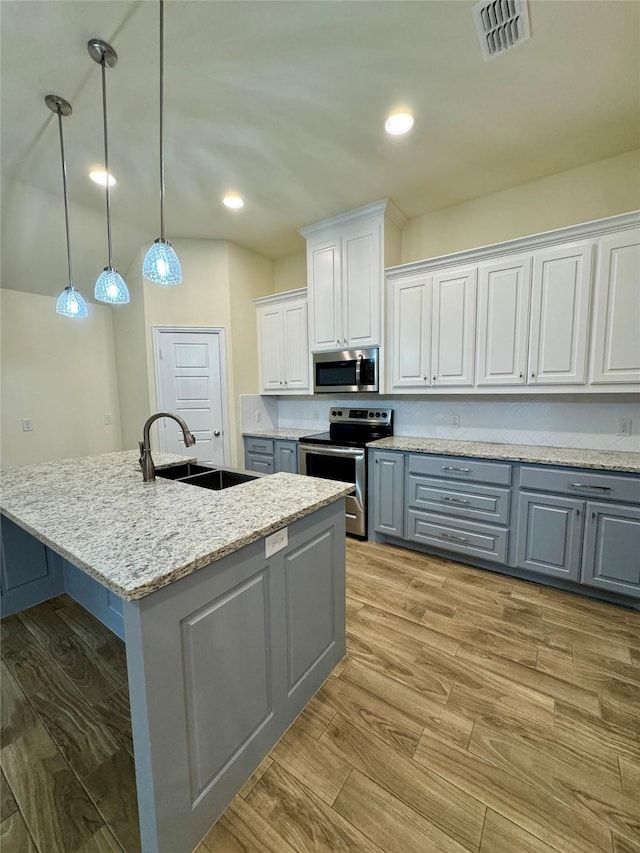 kitchen with gray cabinets, visible vents, appliances with stainless steel finishes, light wood-type flooring, and a sink