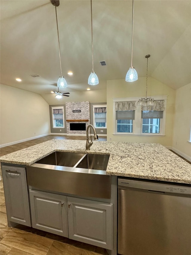 kitchen featuring visible vents, open floor plan, dishwasher, and vaulted ceiling