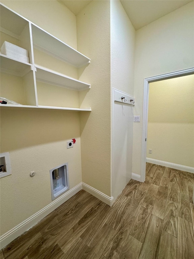 clothes washing area featuring laundry area, baseboards, wood finished floors, and hookup for an electric dryer