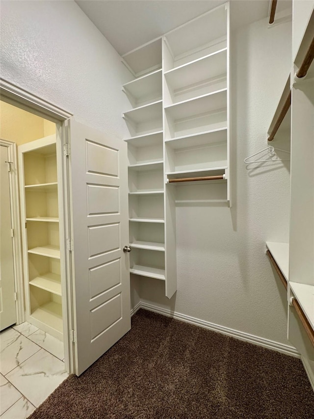 spacious closet featuring marble finish floor