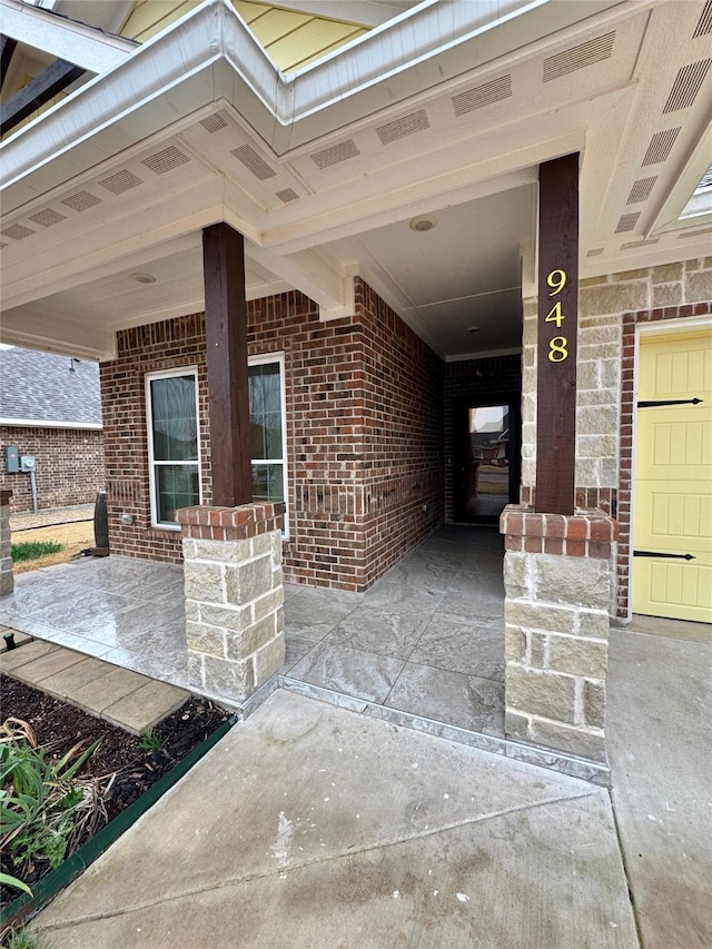 view of exterior entry with brick siding