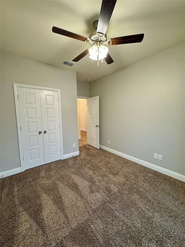 unfurnished bedroom with ceiling fan, carpet floors, baseboards, visible vents, and a closet