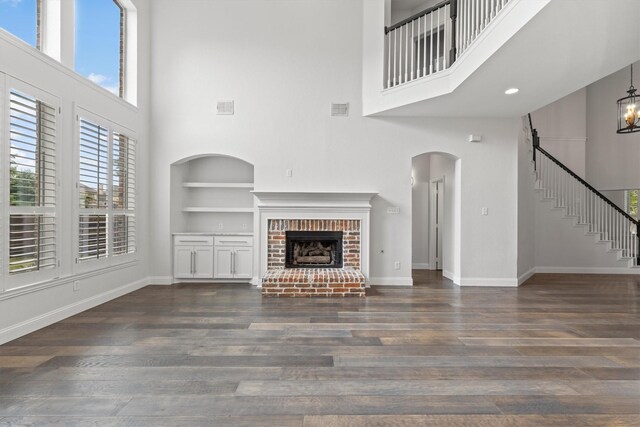 821 High Willow Dr, Prosper, TX 75078 - unfurnished living room featuring a high ceiling, dark wood-style flooring, and built in shelves