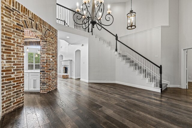 821 High Willow Dr, Prosper, TX 75078 - interior space with a towering ceiling, arched walkways, dark wood-style floors, a chandelier, and stairs