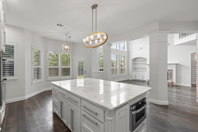 821 High Willow Dr, Prosper, TX 75078 - kitchen featuring dark wood-style flooring, light stone counters, a chandelier, decorative columns, and visible vents