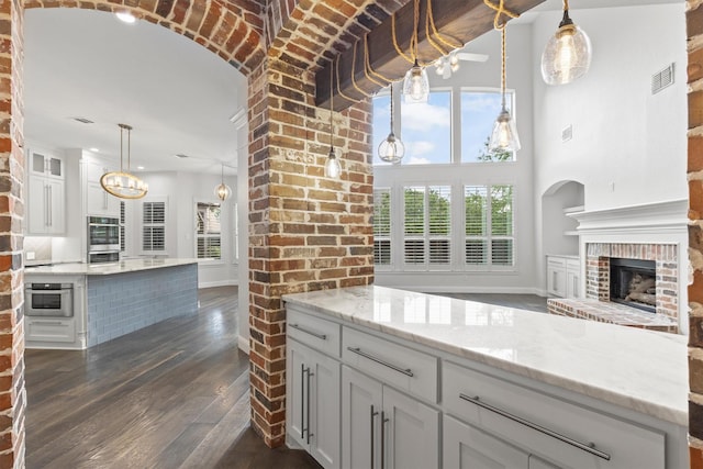 821 High Willow Dr, Prosper, TX 75078 - kitchen featuring visible vents, a fireplace, a center island, white cabinets, and dark wood finished floors