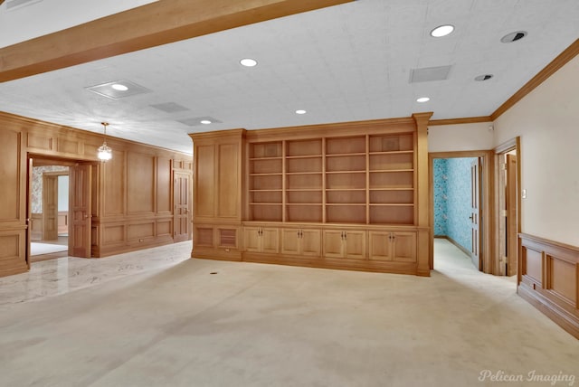 unfurnished living room with crown molding, a decorative wall, and recessed lighting