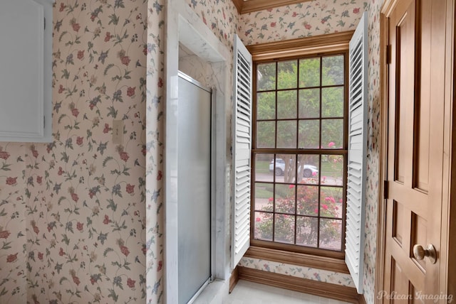 full bath featuring a stall shower, a healthy amount of sunlight, and wallpapered walls