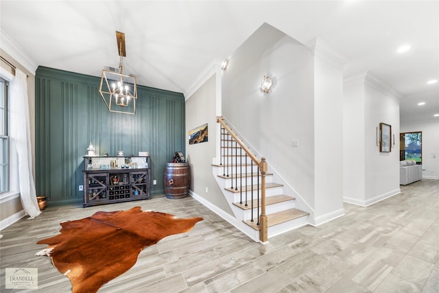 interior space featuring stairs, baseboards, an inviting chandelier, and ornamental molding