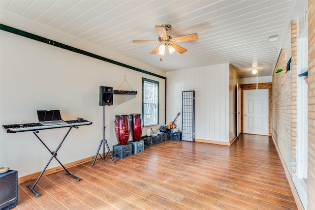 interior space with baseboards, wood ceiling, ceiling fan, and wood finished floors