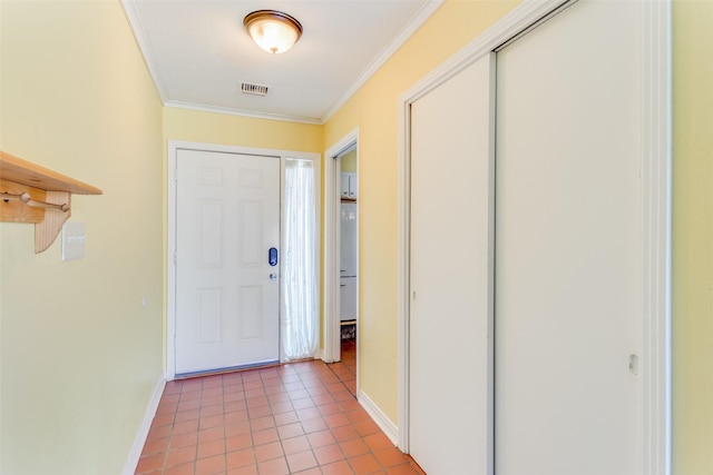 doorway to outside featuring baseboards, ornamental molding, light tile patterned floors, and visible vents
