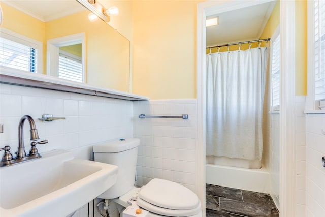 full bathroom with tile walls, curtained shower, a sink, and a wainscoted wall