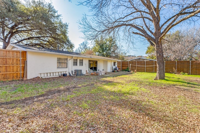 rear view of house with brick siding, central AC unit, a lawn, and a fenced backyard