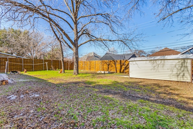 view of yard featuring a fenced backyard, an outbuilding, and a shed