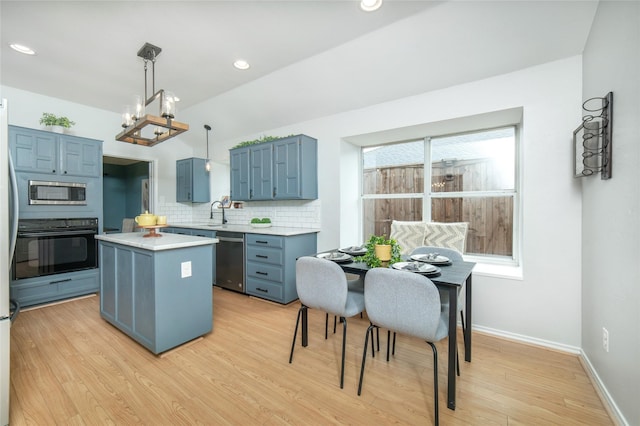 kitchen with blue cabinetry, a center island, tasteful backsplash, light countertops, and stainless steel appliances