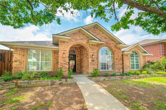 single story home with roof with shingles and brick siding