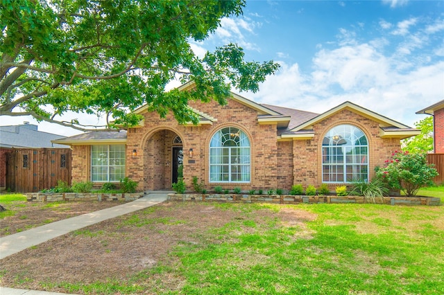 ranch-style home featuring brick siding and a front lawn