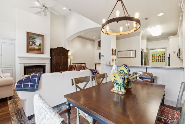 dining space featuring visible vents, a fireplace, recessed lighting, arched walkways, and ceiling fan with notable chandelier