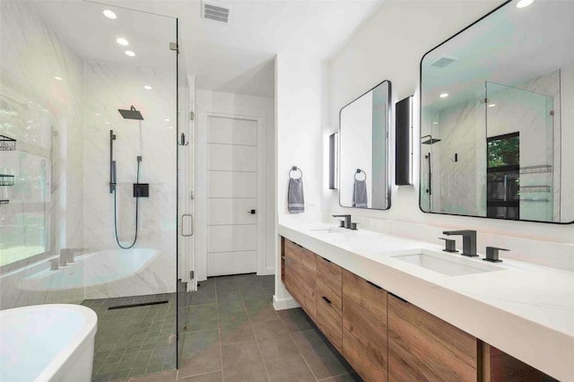 bathroom with visible vents, a freestanding bath, a shower stall, a sink, and tile patterned floors