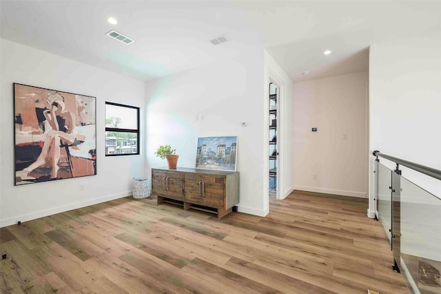 corridor with baseboards, recessed lighting, wood finished floors, and visible vents