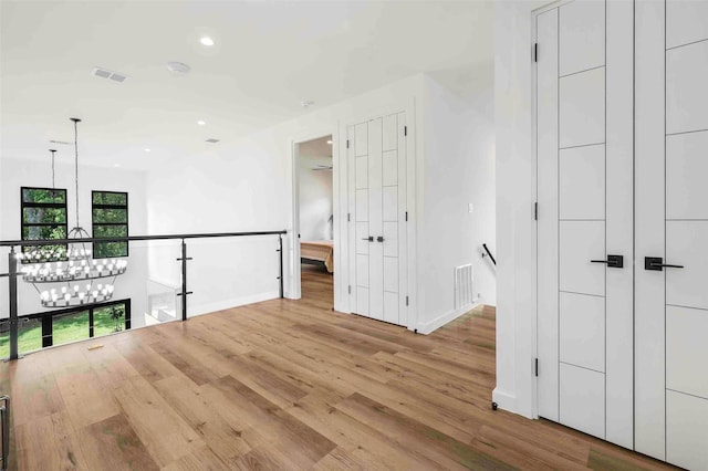 interior space with baseboards, recessed lighting, wood finished floors, and a notable chandelier