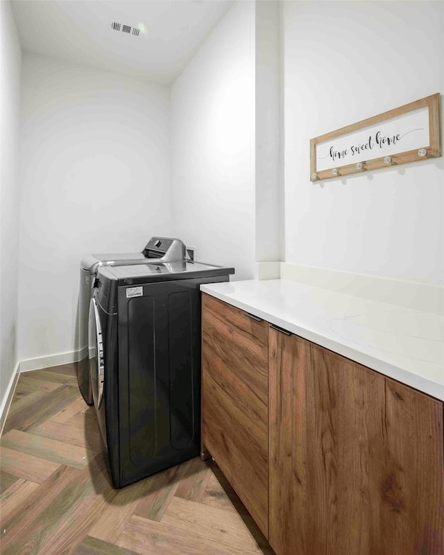 laundry area with separate washer and dryer and visible vents