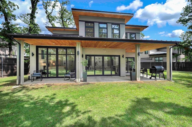 rear view of property featuring a yard, fence, and a patio area