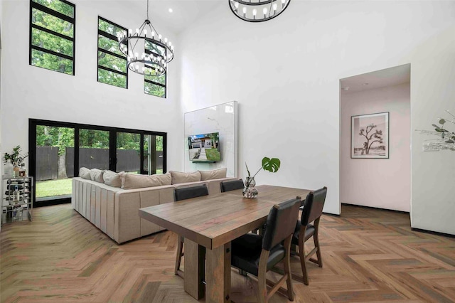 dining space with a notable chandelier and a towering ceiling