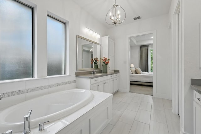 full bath featuring ensuite bathroom, a garden tub, vanity, and an inviting chandelier