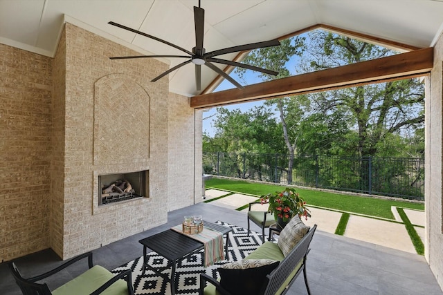 view of patio featuring ceiling fan, an outdoor living space with a fireplace, and fence
