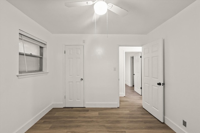 unfurnished bedroom with baseboards, ceiling fan, and dark wood-type flooring