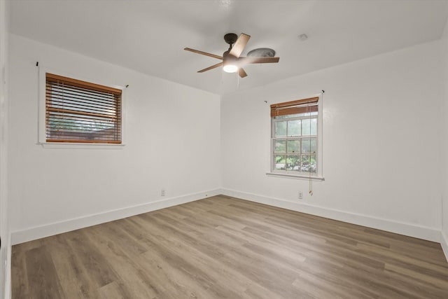 empty room with baseboards, a ceiling fan, and wood finished floors