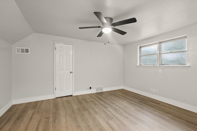 additional living space with baseboards, a ceiling fan, wood finished floors, and visible vents