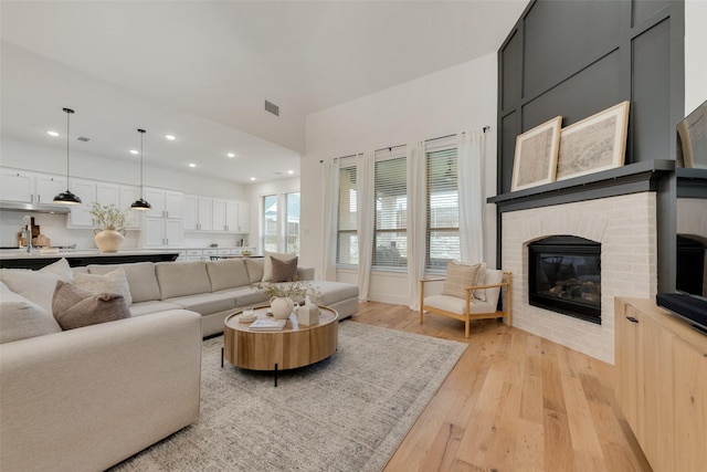 1719 Godello Dr, Mclendon Chisholm, TX 75032 - living area with a brick fireplace, recessed lighting, visible vents, and light wood-type flooring
