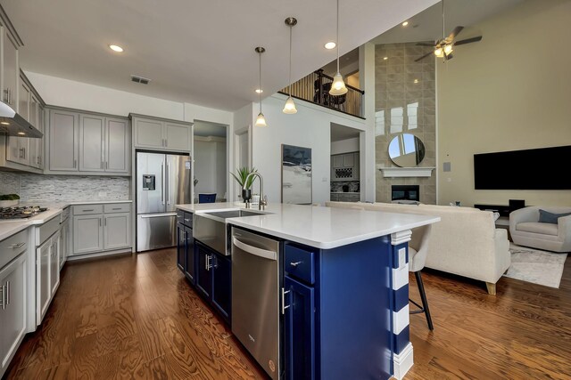 2203 Miranda Ln, Rockwall, TX 75087 - kitchen featuring stainless steel appliances, dark wood-style floors, gray cabinets, a sink, and decorative backsplash