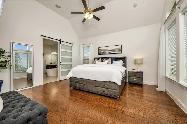 bedroom featuring high vaulted ceiling, multiple windows, dark wood finished floors, and a barn door