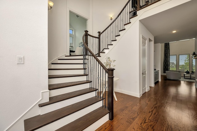 staircase with baseboards, recessed lighting, and wood finished floors