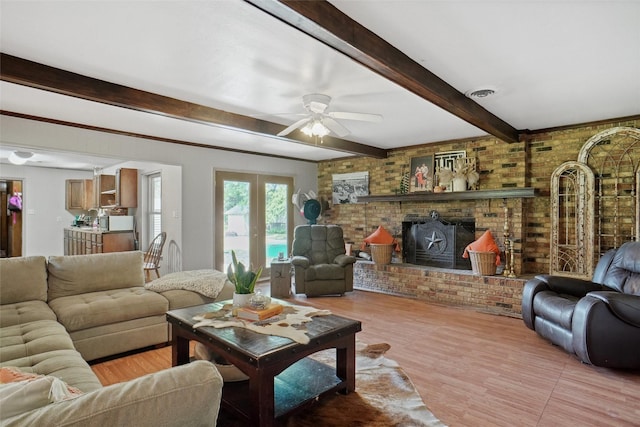 living room with visible vents, brick wall, beamed ceiling, light wood-style floors, and ceiling fan
