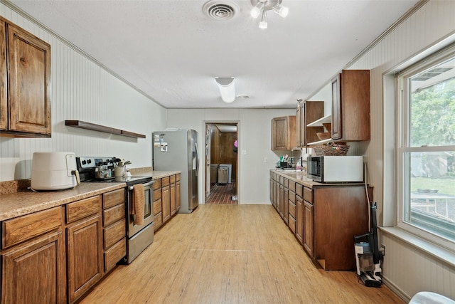 kitchen with visible vents, open shelves, brown cabinets, light wood-type flooring, and stainless steel appliances