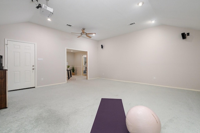 interior space featuring carpet flooring, baseboards, vaulted ceiling, and visible vents