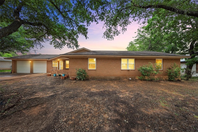 view of front of home featuring brick siding, a garage, and driveway